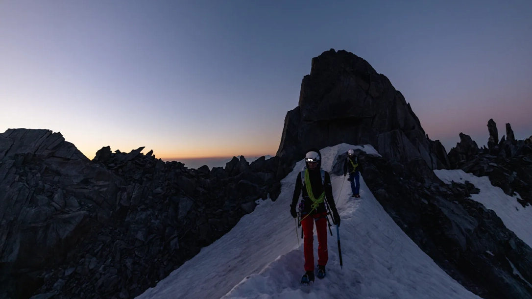 Hikers against a snowy mountain